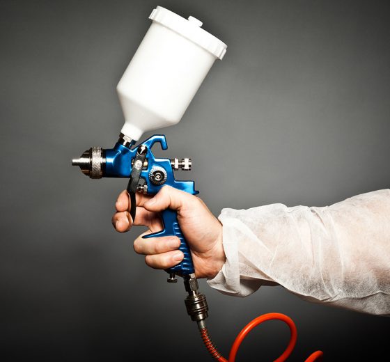 paint spray gun in a hand of a profesional worke
