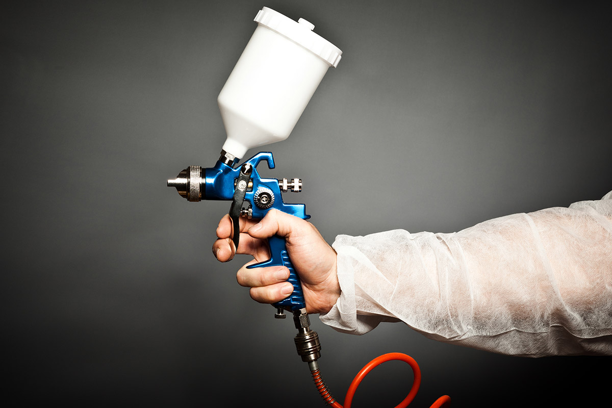 paint spray gun in a hand of a profesional worke